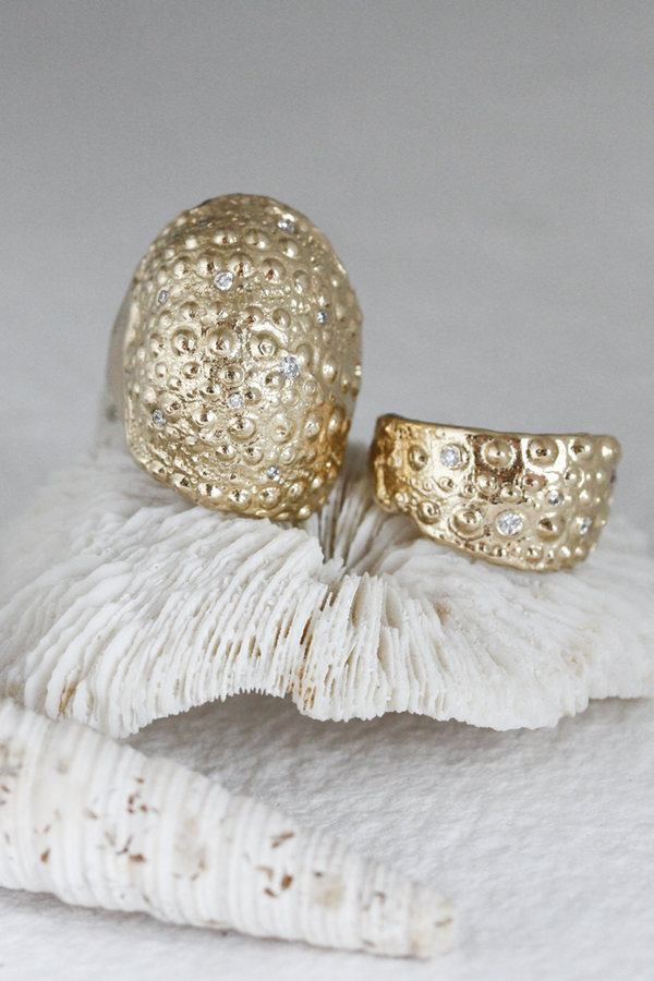 gold textured band with scattered round diamonds alongside other gold band