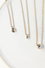 gold ball chain necklace with partial bezel set trillion salt and pepper diamond alongside other diamond necklaces