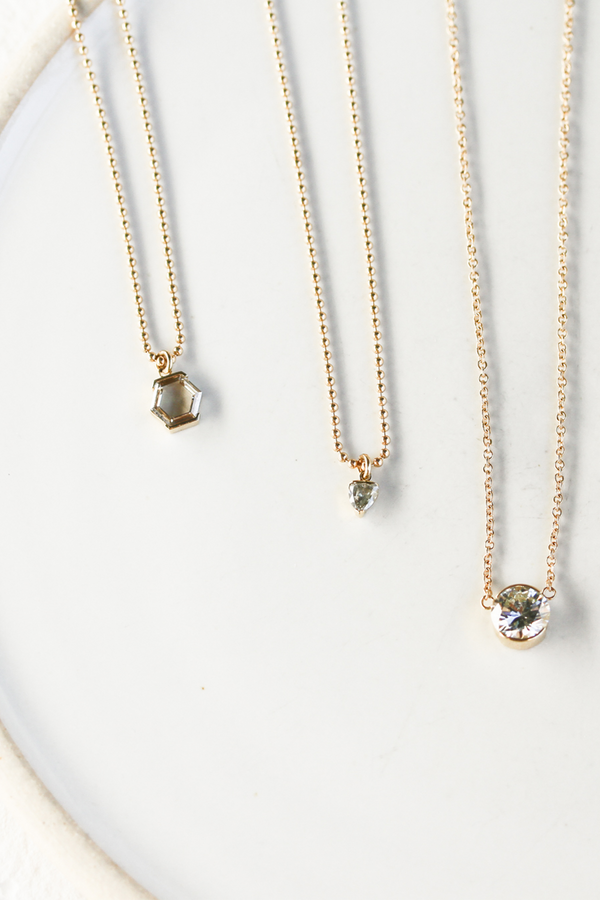 gold ball chain necklace with partial bezel rose cut hexagon white diamond alongside other diamond necklaces
