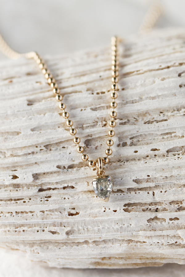 close up of gold ball chain necklace with partial bezel set trillion salt and pepper diamond