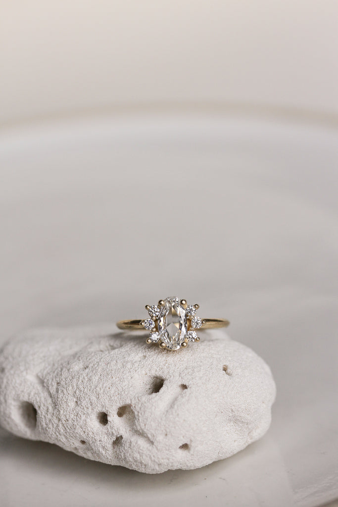 gold ring with elongated rose cut oval diamond and round white diamonds