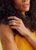 woman wearing knife edge cut gold band alongside other gold jewelry