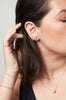close up of woman wearing gold knife edge cut bar shaped stud alongside other gold earrings