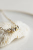 close up of gold cable chain necklace with three bezel set round diamonds