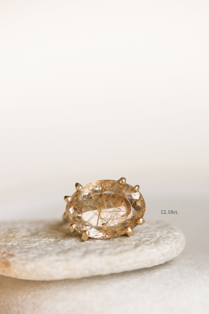 close up of gold 8 prong ring with rutilated quartz