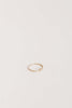 side view of gold textured band with off set bezel set round white diamond