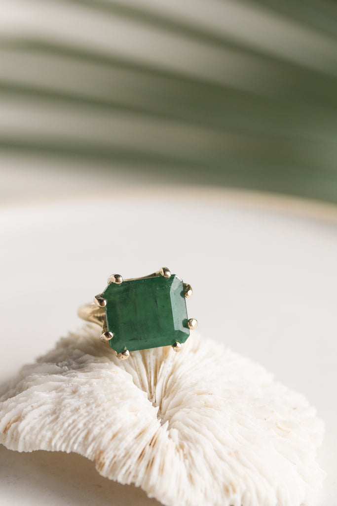 gold textured 8 prong ring with emerald cut emerald