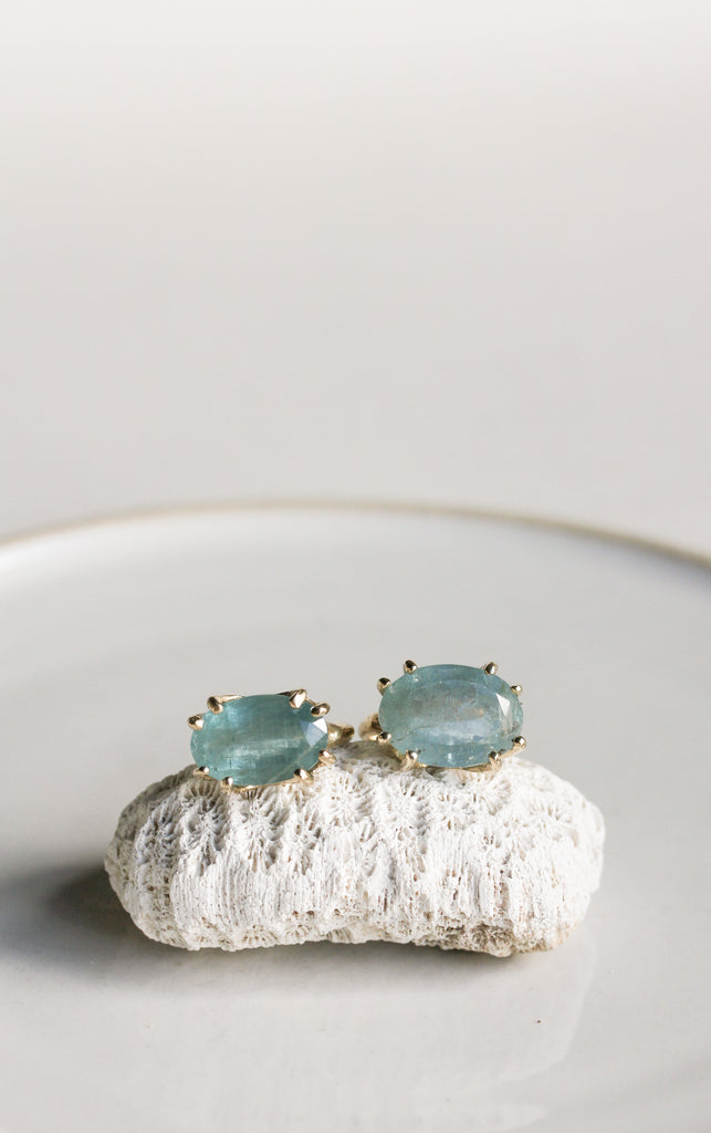 two gold textured 8 prong rings with moss aquamarine