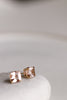 close up side view of gold cushion cut morganite stud earrings