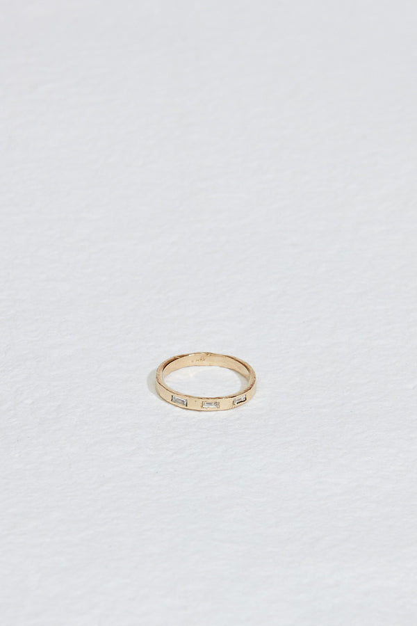 yellow gold band with three baguette white diamonds