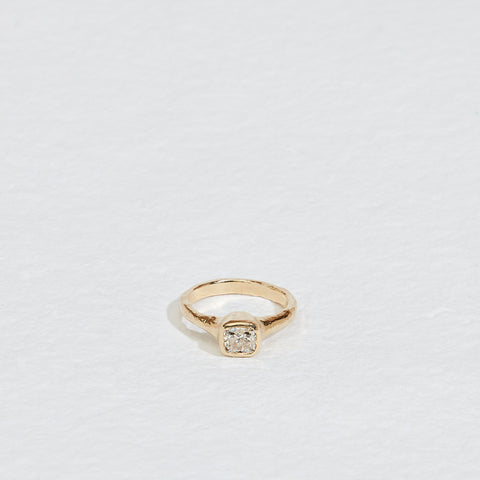 gold ring with cushion cut bezel set white diamond