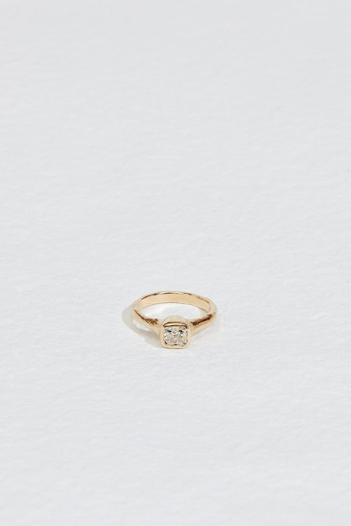 gold ring with cushion cut bezel set white diamond
