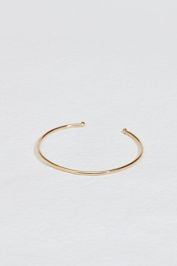 close up of thin gold cuff with knotted ends