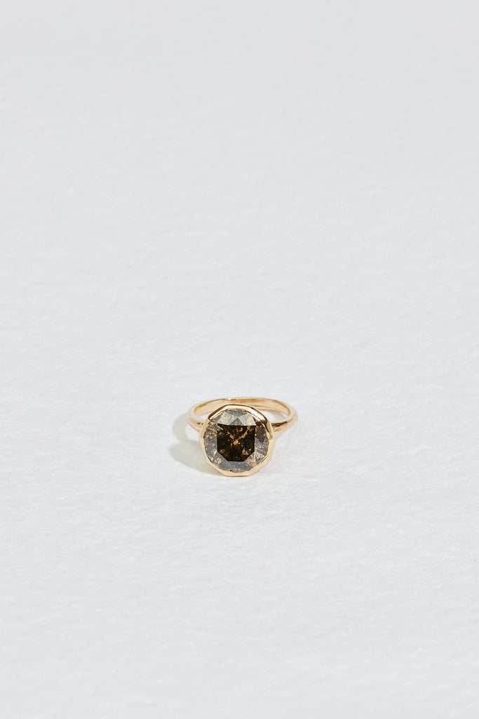 close up of gold ring with decagon bezel set round mocha diamond