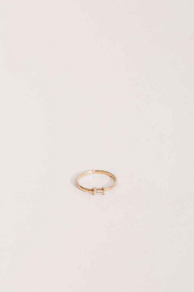 gold band with white baguette diamond