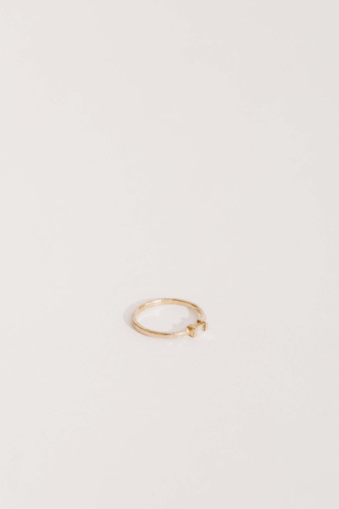 side view of gold band with white baguette diamond