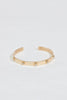 close up of gold cuff bracelet studded with round diamonds
