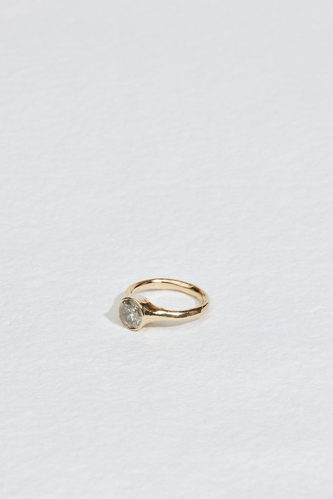 side view of gold ring with bezel set round salt + pepper diamond