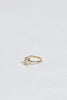 side view of gold ring with bezel set oval white diamond