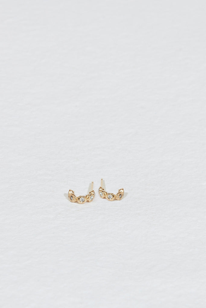 gold semi hoop earrings with five bezel set round white diamonds