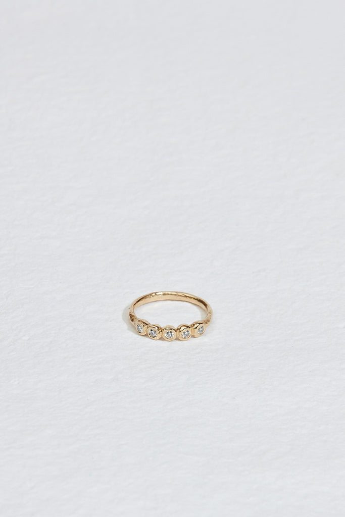 gold ring with five bezel set round white diamonds