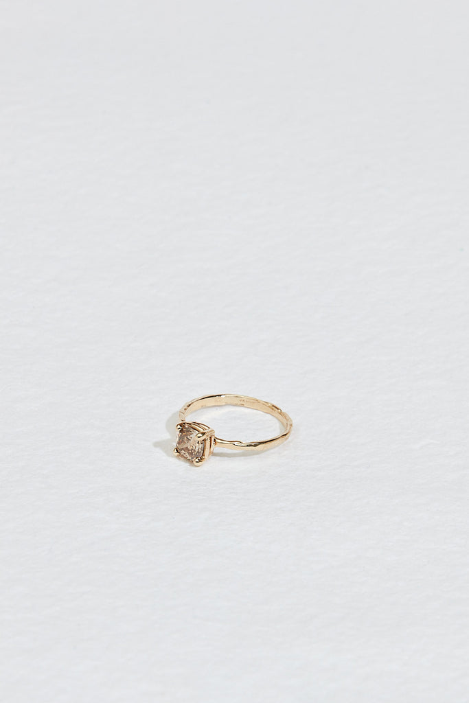 side view of gold four prong ring with cushion cut light champagne diamond