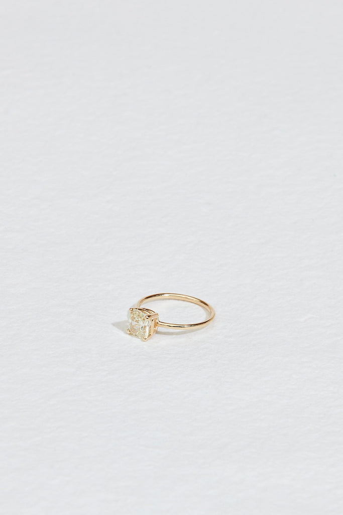 side view of four prong gold ring with cushion cut yellow diamond