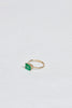 side view of gold four prong twig ring with rectangle emerald
