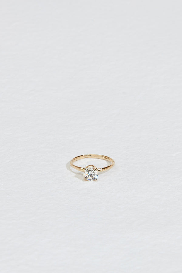 gold four prong ring with round white diamond