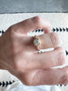 close up of gold ring with cushion cut bezel set white diamond on hand