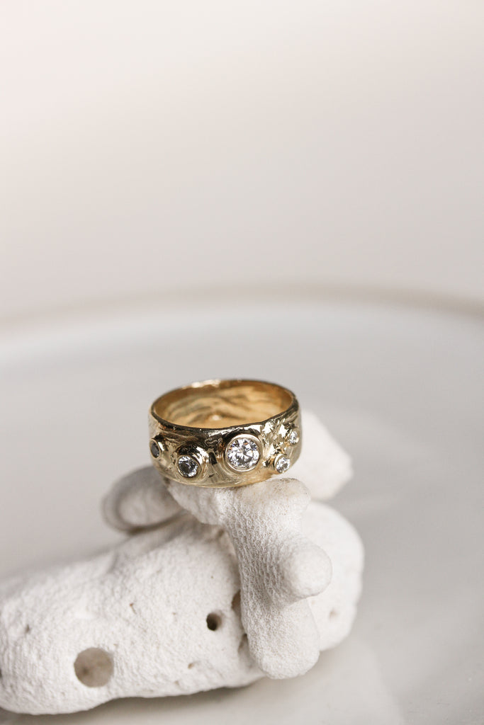 yellow gold cigar band with five scattered round white diamonds