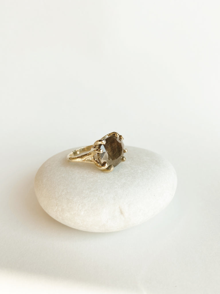 side view of gold 8 prong ring with oval chocolate sapphire