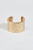 close up of thick gold cuff bracelet with texture