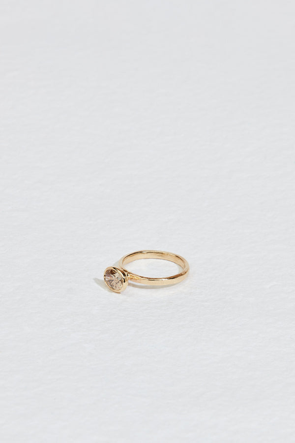 side view of gold ring with bezel set oval champagne diamond