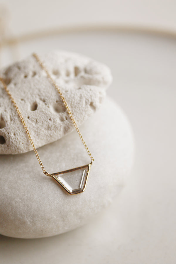 close up of gold necklace with trapezoid shaped diamond slice