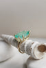 side view of gold 8 prong ring with oval colombian emerald