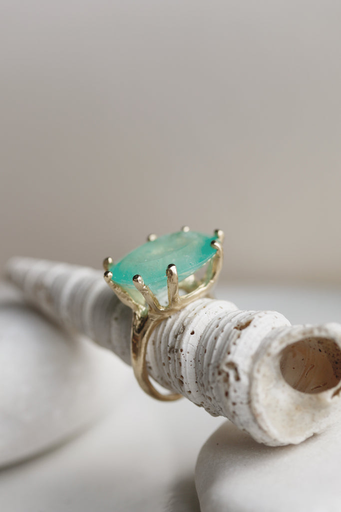 side view of gold 8 prong ring with oval colombian emerald