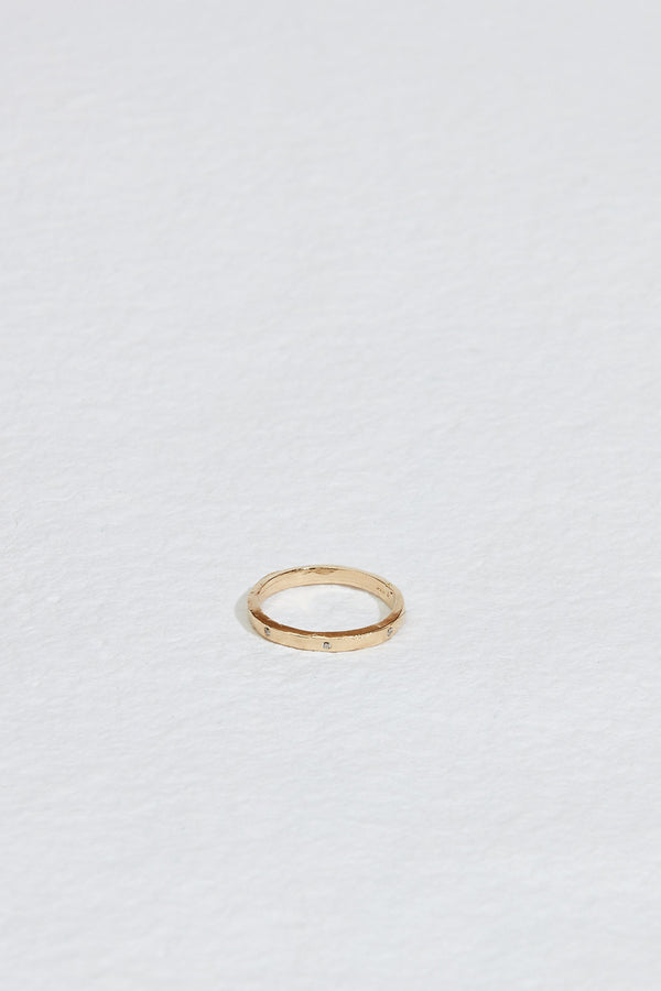 thin gold band with straight sides and round white diamonds