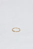 side view of thin gold band with three bezel set round white diamonds